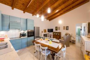 a kitchen and dining room with a table and chairs at Kiko, the Coastline house in Kato Achaia
