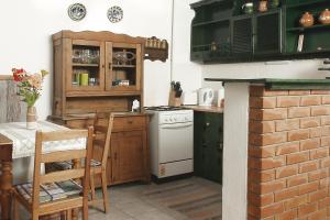 een keuken met een tafel en een fornuis top oven bij Nevenincs Vendégház in Bátor