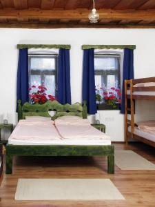 a bedroom with a green bed with blue curtains at Nevenincs Vendégház in Bátor