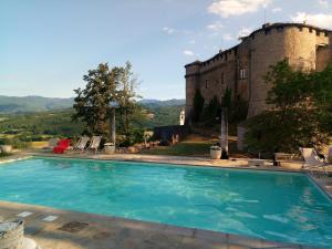 a swimming pool in front of a castle at Castello Di Compiano Hotel Relais Museum in Compiano