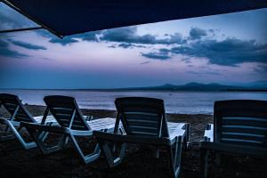 three lawn chairs sitting on the beach at dusk at Garden Inn Resort Sevan in Sevan +58 photos
