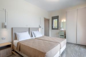 a bedroom with a large bed and a table at Kefalonia Stone Villas - Villa Petros Kefalonica in Trapezaki +80 photos