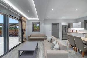 a living room with a couch and a table and a kitchen at Kefalonia Stone Villas - Villa Petros Kefalonica in Trapezaki