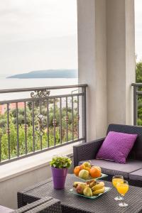 una mesa con una bandeja de fruta en el balcón en Apartments Jure, en Makarska