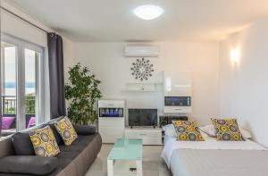Una sala de estar con un sofá y un televisor. en Apartments Jure, en Makarska