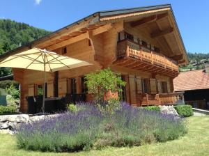 una grande casa in legno con un ombrello nel cortile di Chalet Courage a Champéry