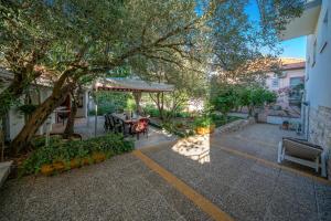 an outdoor patio with a table and a tree at Apartmani Patača in Vodice