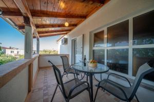 a patio with a table and chairs on a balcony at Apartmani Patača in Vodice