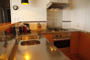 cocina con fregadero y fogones en Te Huia en Whangarei Heads