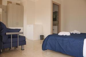 a bedroom with a blue bed and a chair at Villa Angela in Scalea