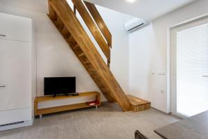 a living room with a tv and a staircase at Holiday house in Terme Čatež in Brežice