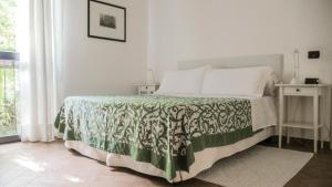 1 dormitorio con 1 cama con manta verde y blanca en Appartamento Quattrocolli en Quattro Castella