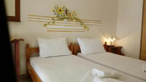 a bedroom with two beds and a flower arrangement on the wall at Kadmos in Loutra Edipsou