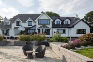 a large white house with black windows at Railway Country House in Gorey