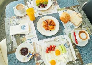 a table topped with plates of breakfast foods and coffee at MyContinental Suceava in Suceava