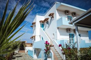 a white building with flowers in front of it at Babalogo Apartments in Malia