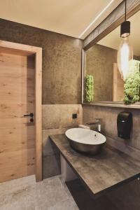 baño con lavabo grande y espejo en Alpine Resort Sportalm en Sankt Leonhard im Pitztal