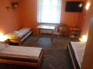a room with two beds and a table and a television at Pokoje Gościnne Monika Szling in Zakopane