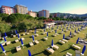 a bunch of chairs and blue umbrellas in a field at Marion apartment in Portorož
