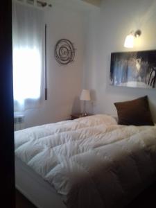 een wit bed in een slaapkamer met een raam bij Apartament FRESER II in Ribes de Freser