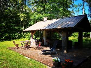 une terrasse en bois avec un kiosque, une table et des chaises dans l'établissement Kotka Farm, à Saareküla