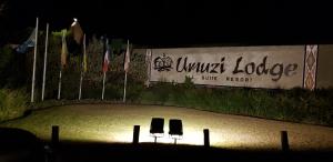 two chairs sitting in the sand in front of a sign at Umuzi Lodge in Secunda