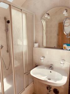 a bathroom with a sink and a shower at Pension Lindenhof in Grasbrunn