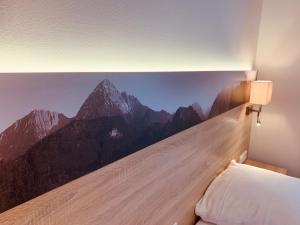1 dormitorio con un mural de montaña en la pared en Pension Lindenhof, en Grasbrunn