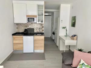 a kitchen with white cabinets and a living room at Apartamento Dreamplace in Finestrat