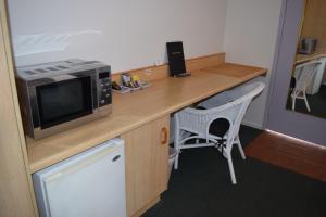 a kitchen with a microwave and a table at Warwick Vines Motel in Warwick