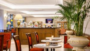 a restaurant with tables and chairs and a bar at Hotel Bellevue - Liburnia in Opatija