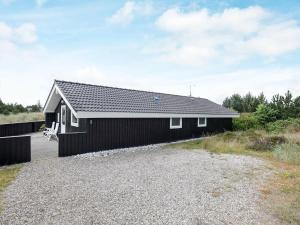 ブラーバンドにあるThree-Bedroom Holiday home in Blåvand 15の黒屋根の黒家
