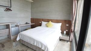 a bedroom with a large white bed and a window at Tree House 民宿證號2316 民宿證號2350 in Hualien City +96 photos