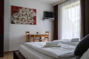 Habitación de hotel con 2 camas y mesa en Haus Lebensfreude en Magland