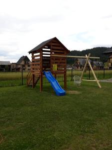 a playground with a blue slide and a basketball hoop at Pod Świerkami in Kacwin