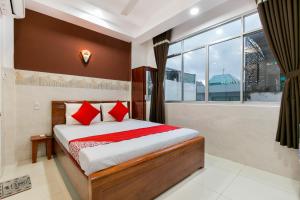 a bedroom with a bed with red pillows and a window at ANH KHOA 1 HOTEL Quận 2 in Ho Chi Minh City
