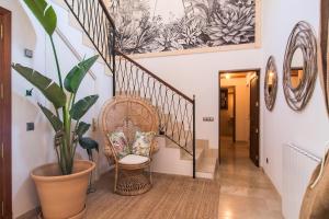 un pasillo con escaleras con una silla y una planta en Villa Pula Golf by Priority, en Son Servera