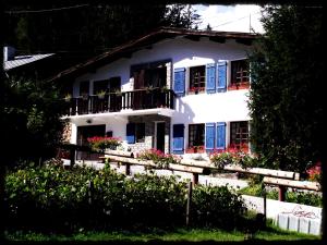 una casa blanca con puertas azules y una valla en Chamonix Lodge, en Chamonix-Mont-Blanc