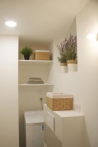 昂蒂布的住宿－STUDIO VIEIL ANTIBES Marché Provençal，墙上有植物的白色书架的房间