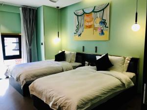 two beds in a room with green walls at Moon and Chalice Boutique Hotel in Kunming