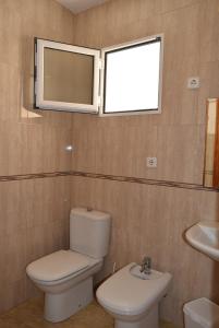a bathroom with a toilet and a sink and a window at Mar Menor Lo Pagan Apartment in San Pedro del Pinatar