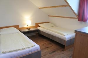 a room with two beds and a table with a lamp at Ferienwohnungen Kaiser in Gallizien +36 photos