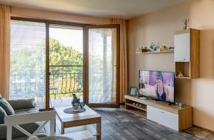 a living room with a tv and a large window at Briz MK Apartment in Ravda