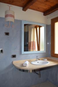 a bathroom with a sink and a mirror at Hotel Soffio di Vento in Arbus
