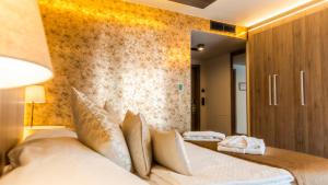 ein Schlafzimmer mit einem großen Bett und einer Wand in der Unterkunft Hotel AquaCity Seasons in Poprad