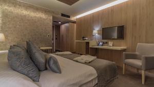 um quarto de hotel com uma cama e uma televisão de ecrã plano em Hotel AquaCity Seasons em Poprad