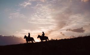 two people riding horses on a field at sunset at The Yurts at Margo's Garden, Kiroro in Akaigawa