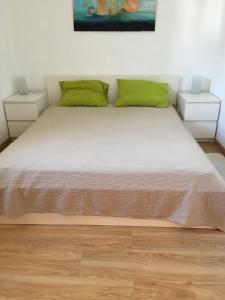 1 dormitorio con 1 cama grande con almohadas verdes en Vila Fuzeta - Solar dos Mouros, en Porches
