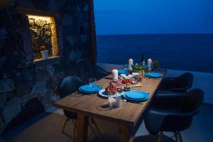a wooden table with candles and food on top of it at Abelomilos Exclusive Villa in Imerovigli