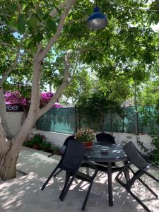 un tavolo e sedie su un patio sotto un albero di casa La sorgente di Carlo Magno a Otranto